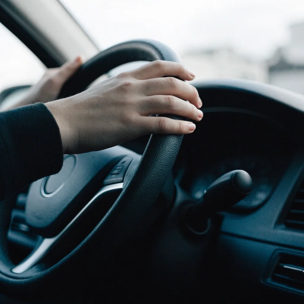 Autokoulun auton taustapeili ja tuulilasinpyyhkimen varsi lähikuvassa